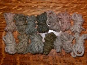 Two rows of seven tiny balls of yarn, from silver to lavender to pink.