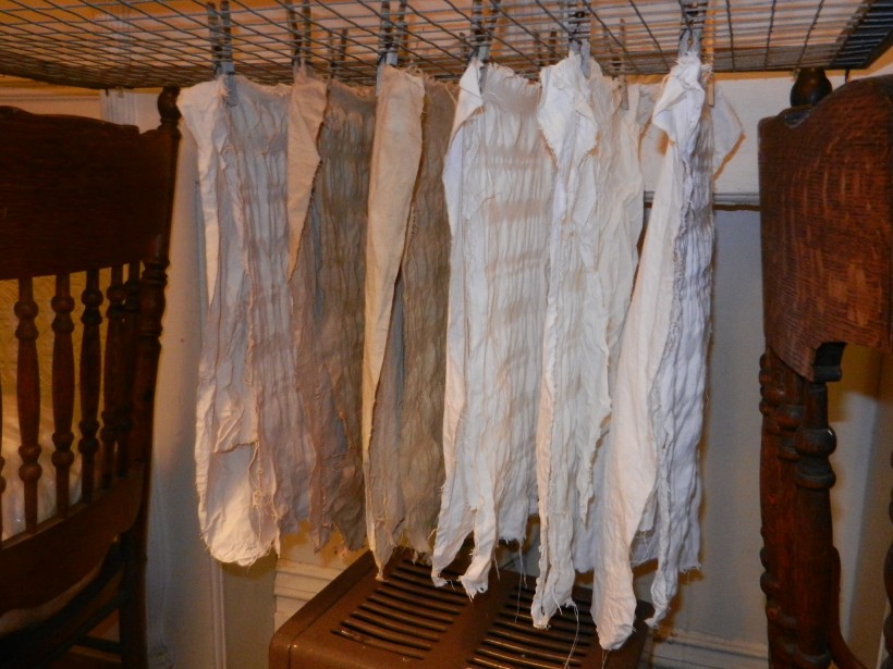 Slightly different shades of tans and creams on six sets of cotton, drying over a heater.